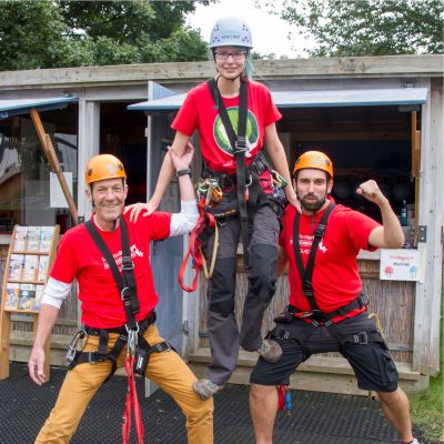 Zwei Erwachsene und eine Jugendliche bilden eine Pyramide