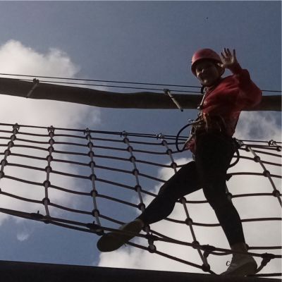 Jugendlicher klettert in einem Schiffsnetz