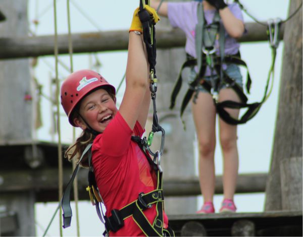 Ein Kind hngt in einer Sicherung und lacht in die Kamera