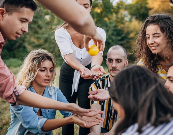 Junges Team steht beisammen und streckt die Hnde in die Mitte