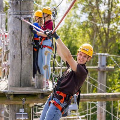 Anfahrt zum Kletterpark Drei Erwachsene klettern in der Anlage