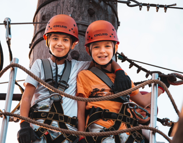 Zwei lachende Kinder beim klettern schauen in die Kamera