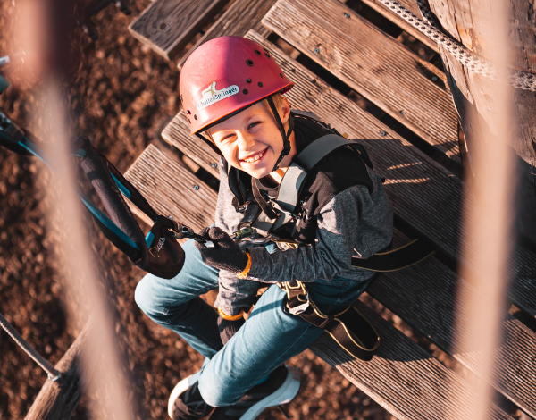 lachendes Kind mit Helm schaut in die Kamera