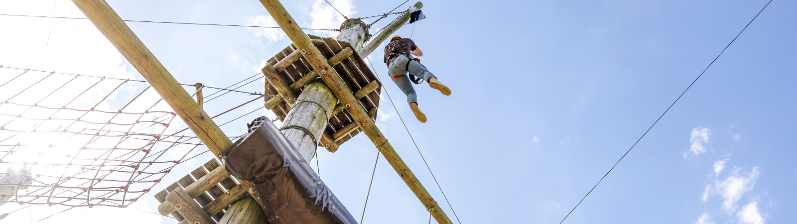 Erwachsener wagt den Sprung im Kletterpark